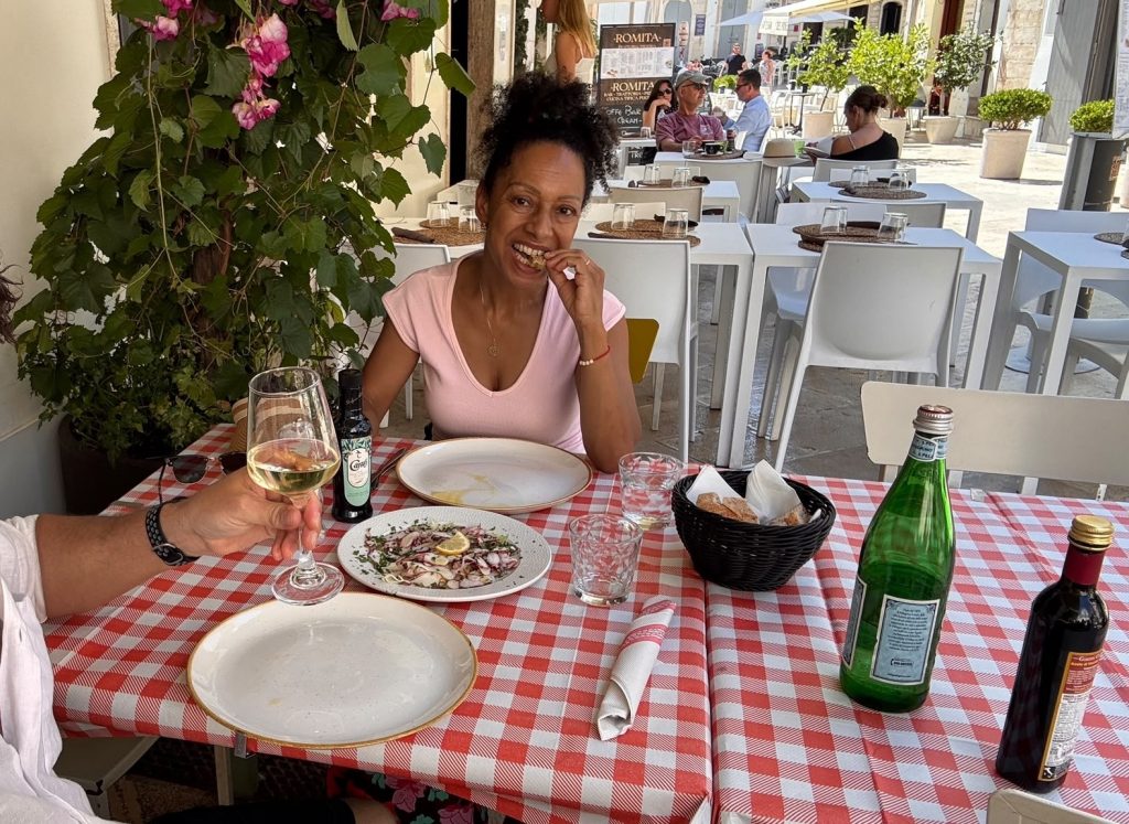 Eine Frau sitz in einem Restaurant und führt sich Essen zum Mund