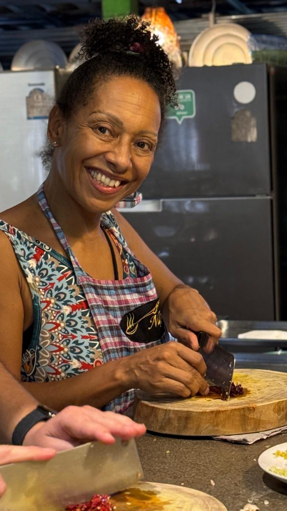 Eine Frau schneidet etwas auf eine Holzschneidebrett