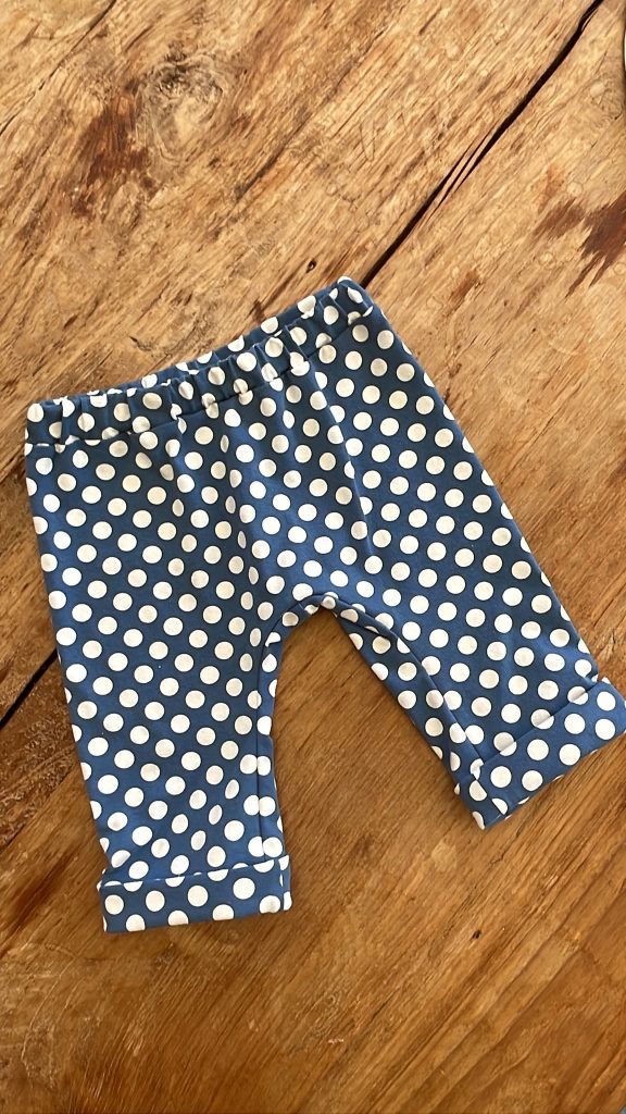 Eine gepunkteten Hose liegt auf einer Holzplatte