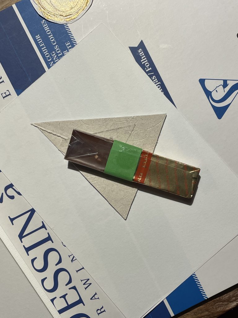 Eine Merci Schokolade an einen Papiertannenbaum geklebt