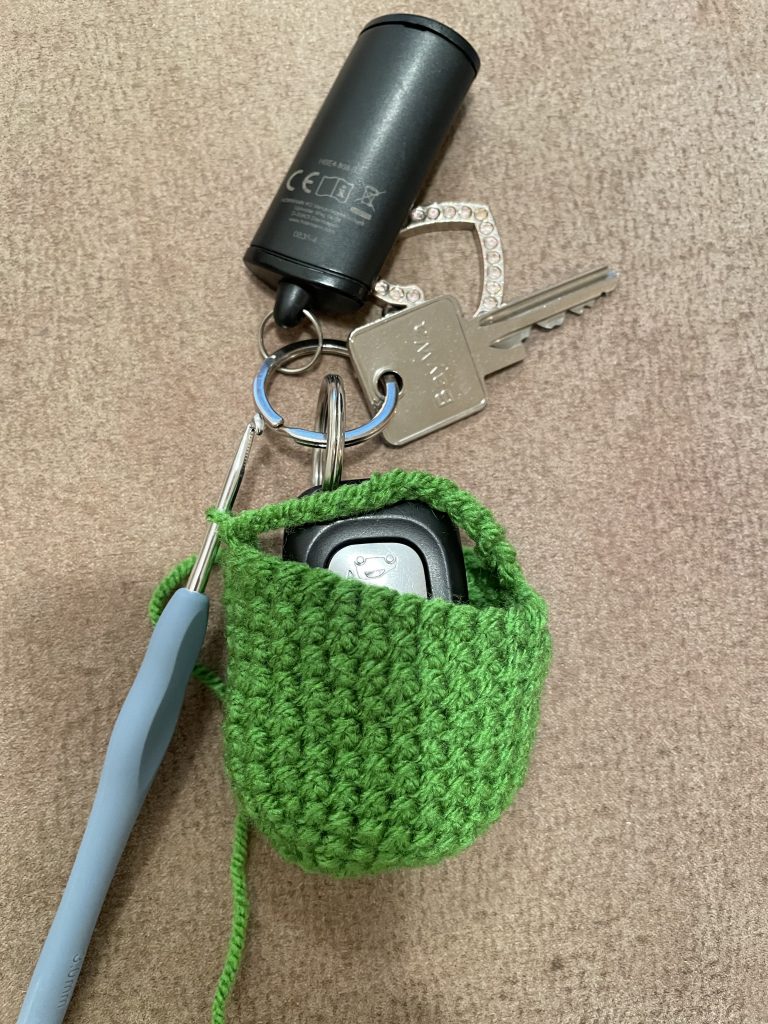 Ein Schlüsselfresserchen wird um einen Autoschlüssel gehäkelt