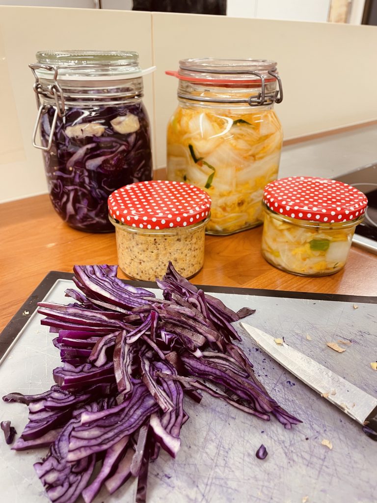 verschieden gefühlte Einmachgläser. eines mit fermentiertem Rotkohl,