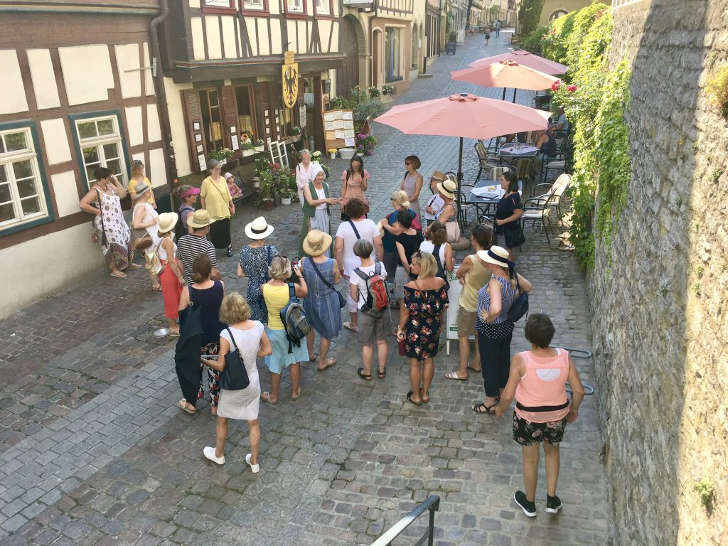 Stadtführung mit vielen Menschen in Bad Wimpfen. rechts die Stadtmauer, links Fachwerkhäuser