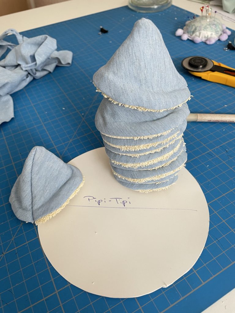 Pipi-Tipis liegen gestapelt auf einer Zuschenidematte. Ein Rollschneider liegt rechts davon