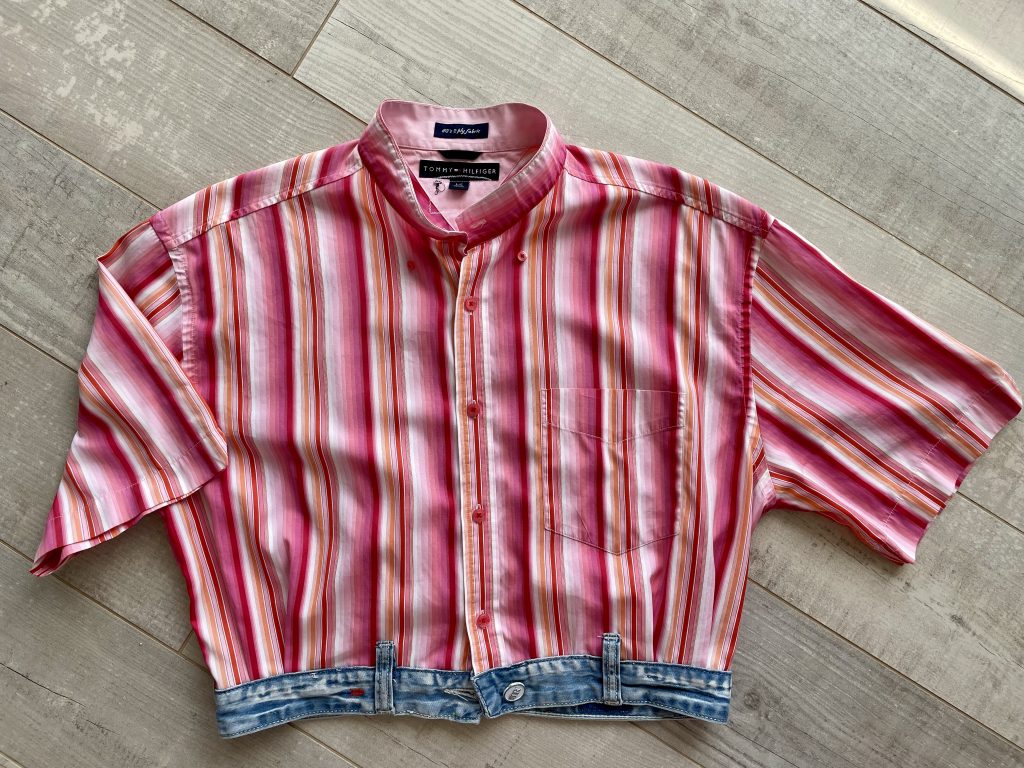 Ein in pinktönenen gestreiftes Kurzarm-Hemd mit einem Bündchen aus einer Jeanshose