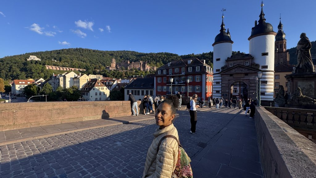 Blick auf die Alte Brücke in Heidelberg an einem sonnigen Herbsttag, mit vielen Spaziergängern und der historischen Altstadt im Hintergrund