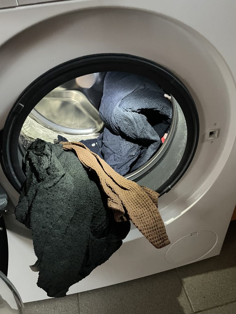 Eine geöffnete Waschmaschine mit Wäsche darin