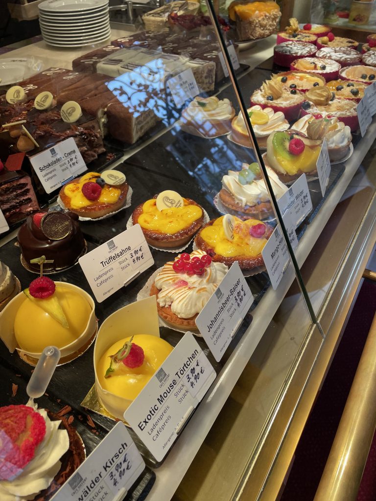 Auslage einer Konditorei mit vielen verschiedenen kleinen Kuchen