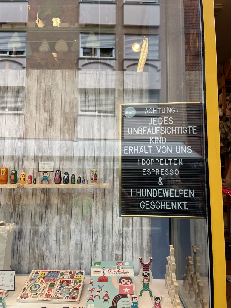 Ein Schild in einem Spielzeugladen mit der Aufschrift: Achtung: Jedes unbeaufsichtigte Kind erhält von uns 1 doppelten Espresso und 1 Hundewelpen geschenkt