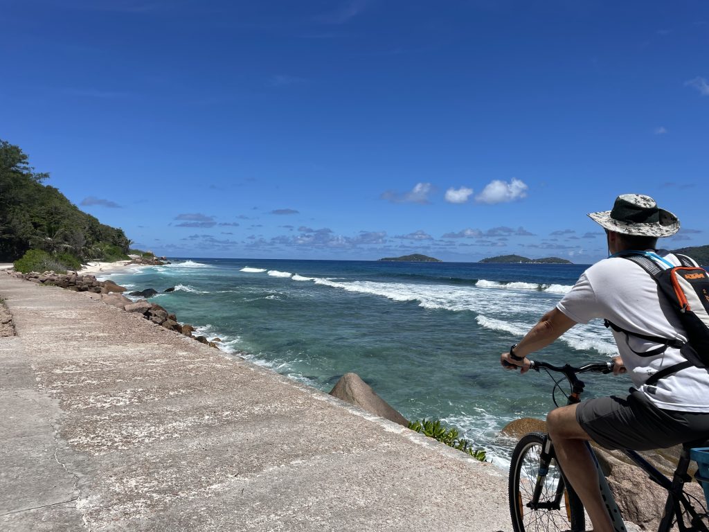 Ein Mann fährt mit dem Fahrrad am Meer entlang