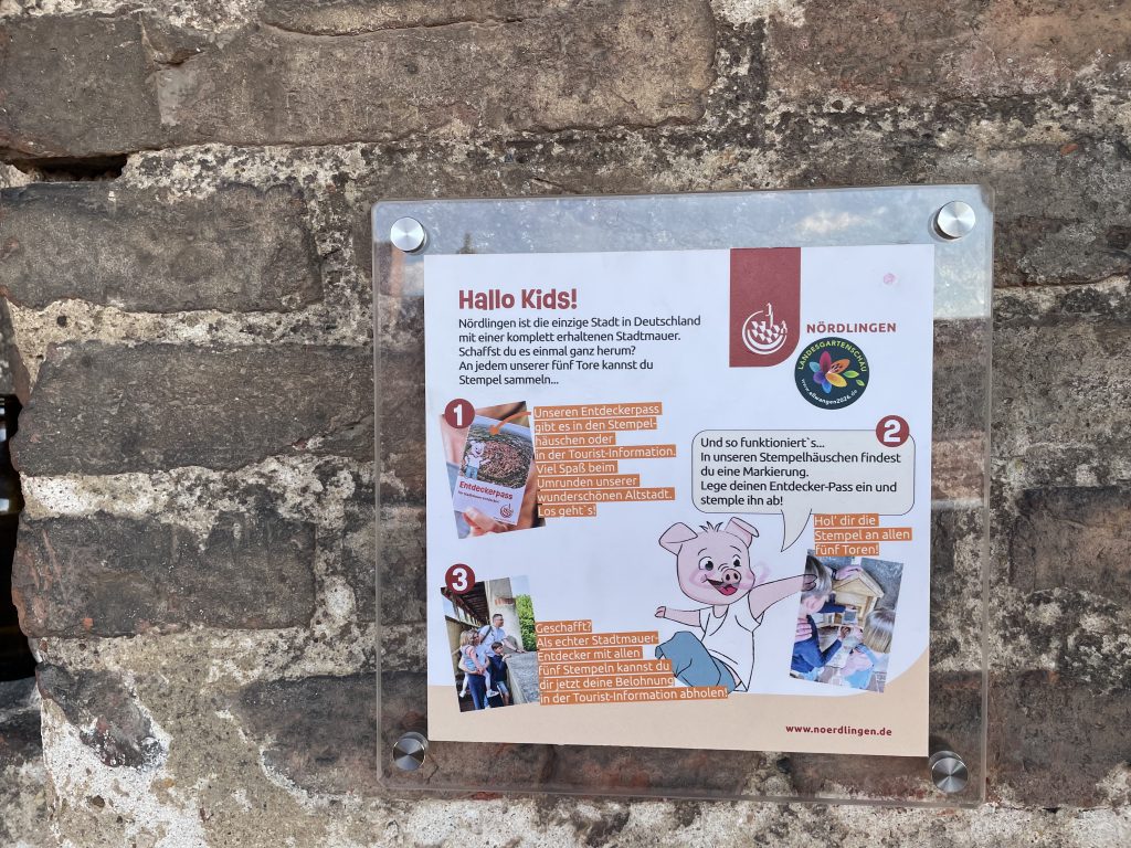 Infotafel in Nördlingen für Kinder mit Entdeckerpass – Stempeljagd entlang der historischen Stadtmauer und Stadttore in der mittelalterlichen Altstadt von Nördlingen, Bayern.