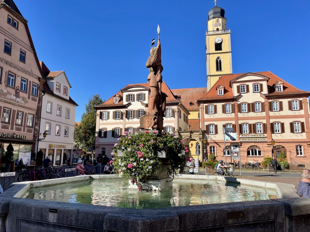 Ein schöner Brunnen auf dem Marktplatz in Bad Mergentheim. In der Mitte mit Blumen geschmückt