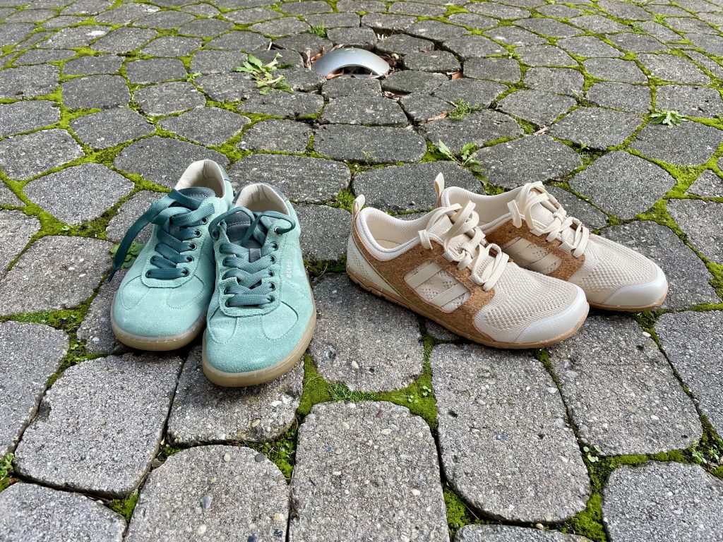Zwei Paar Schuhe stehen auf einem gepflasterten Boden