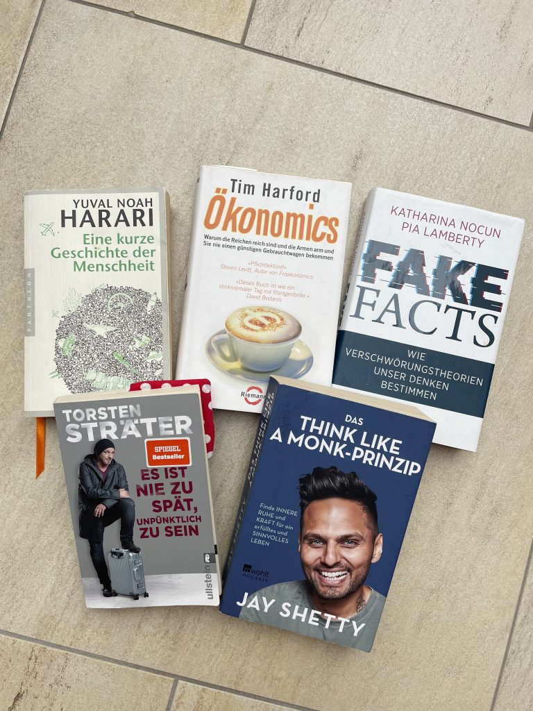 Fünf verschieden Bücher liegen auf einem Fliesenboden.