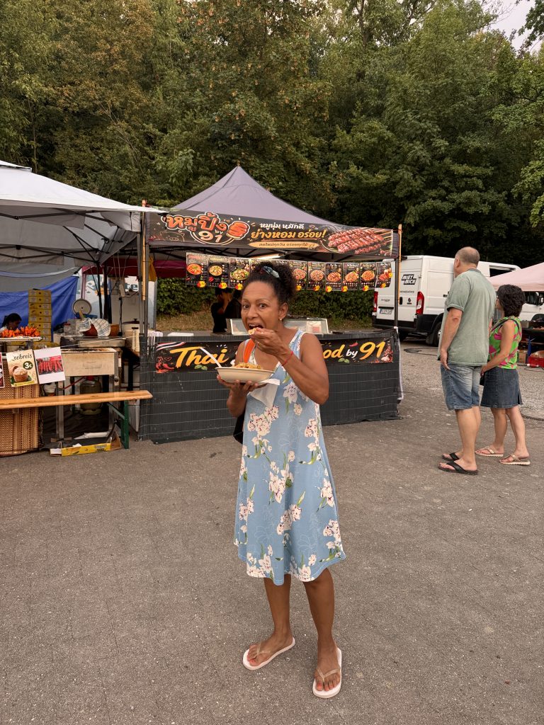 Eine Frau isst im stehen auf einem Thailändischen Food Markt in Heilbronn