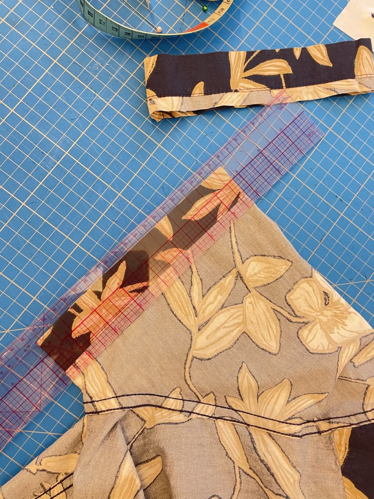 Auf einem Ärmel eines Hemdes liegt eine Lineal