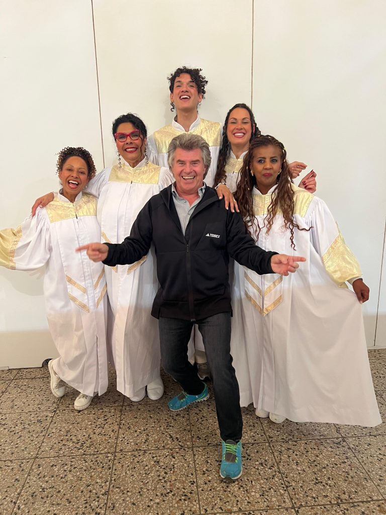 Eine Gospelgruppe "Golden Voices of Gospel" stehen um Andy Borg herum